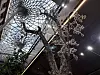 Kunstvoller Baum mit verzweigten Ästen unter einer geometrischen Glaskuppel