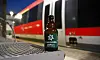 Flasche Karlsberg UrPils auf einem Bahnsteig vor einem Zug der Deutschen Bahn