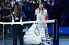 Naomi Osaka betritt bei den US Open in New York den Tennisplatz, während Anastasia Zakharova am Netz steht.