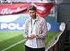 Simon Rolfes von Bayer 04 Leverkusen steht mit Handy am Spielfeldrand in Wiesbaden.