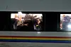Fahrgäste an den Fenstern eines ICE in Gmünden am Main, darunter ein farbiger Zugstreifen