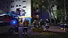 Feuerwehrleute und Einsatzfahrzeuge stehen nachts vor einem Hochhaus in Hamburg.