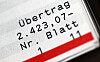 Nahaufnahme eines Kontoauszugs mit dem Eintrag „Übertrag 2.423,07-“ und rotem Balken.