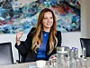 Magdalena Finke spricht im dpa-Interview an einem Tisch vor abstrakter Kunst.