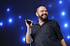 Marian Gold von Alphaville singt mit Mikrofon vor blau beleuchteter Bühne beim Rainbow Festival in Köln.