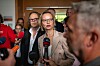 Katja Wolf spricht in Erfurt vor mehreren Mikrofonen, umgeben von Medienvertretern und weiteren Personen.