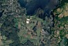 Satellitenbild mit Siedlungen, Feldern, Wäldern und einem Gewässer in abwechslungsreicher Landschaft.