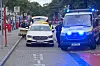 Polizei kontrolliert ein Mercedes-Taxi in der Busspur der Kirchenallee neben einem Streifenwagen mit Blaulicht.