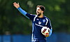 Immanuel Pherai hebt beim HSV-Training den Arm und hält einen Fußball.