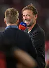 Jürgen Klopp lächelt im Gespräch mit Thomas Hitzlsperger und spricht in ein Sky-Sport-Mikrofon.