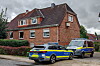 Zwei Polizeifahrzeuge stehen vor einer Backstein-Doppelhaushälfte in Nettelnburg.