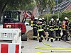 Feuerwehrleute sichern eine beschädigte Gasleitung neben einem Minibagger in Hamburg-Niendorf.