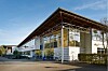 Moderne Gewerbehalle mit Glasfassade, weit auskragendem Dach und begrüntem Außenbereich