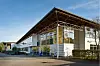 Moderne Gewerbehalle mit Glasfassade, weit auskragendem Dach und begrüntem Außenbereich