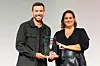 Ein Mann und eine Frau präsentieren gemeinsam eine Trophäe beim Hamburger Gründerpreis 2026.