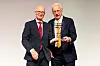 Zwei Männer im Anzug präsentieren beim Hamburger Gründerpreis 2026 gemeinsam eine Auszeichnung.