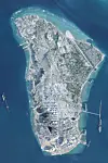 Satellitenaufnahme der iranischen Insel Kharg mit Industrieanlagen und Hafenbecken im Persischen Golf.