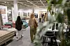 Kundschaft stöbert zwischen Möbeln und Wohnaccessoires in einem hellen Einrichtungshaus.