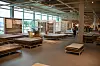 Möbel-Showroom mit Holztischen, Podesten und Wohnbereichen in einer lichtdurchfluteten Industriehalle