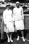 Cilly Aussem und Hilde Krahwinkel posieren 1931 mit Tennisschlägern am Netz in Wimbledon.