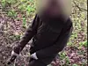 Die Jägerin nähert sich der gefangenen Katze mit einer Waffe.