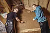 Josef und Camille lehmen in einer historischen Bauernkate eine Wand.