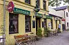 Gelbe Backsteinfassade der Gaststätte Drei Eichen mit Außensitzplätzen in Hamburg-Groß Borstel.