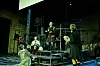 Vier Schauspieler stehen auf dem Treppengerüst, aus recycelten Materialien auf der Bühne.