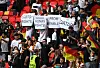 Fans halten Plakate hoch, auf denen LGBTQ+Rechte gefordert werden