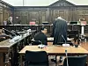 Ein Mann sitzt im Gericht und schaut nach hinten in die Kamera