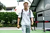 Mick Schumacher geht in Mercedes-Shirt lächelnd auf die Kamera zu