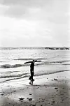 Foto von 1949. Ein Junge sammelt Holz am Strand.