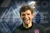 Thomas Müller vor Vancouver-Logo