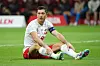 Robert Lewandowski sitzt auf dem Rasen.