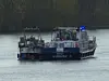Polizeiboot mit Blaulicht auf der Süderelbe bei Hamburg-Wilhelmsburg neben einem manövrierunfähigen Boot.