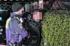 Ein Polizeibeamter nimmt den unkenntlich gemachten Angeklagten fest.