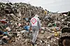 Ein Mitglied vom Bund für Umwelt und Naturschutz Deutschland trägt bei einem Medientermin zur Räumung einer illegalen Müllkippe einen Schutzanzug mit Warnzeichen.