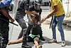 Polizisten halten einen Demonstranten in Tunesien gewaltsam fest.