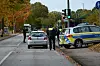 Polizisten stehen am Unfallort an einer Bushaltestelle.