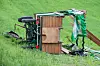 Eine umgestürzte Pferdekutsche liegt auf einem Feld.