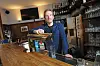 Wirt des „Aalhaus“ Timo Wiesmann an der Bar vor einem schwarzen Bildschirm.