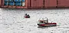 Mit mehreren Booten sucht die Hamburger Feuerwehr die Elbe nahe der Sietas Werft ab.