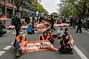 Demonstranten der Letzten Generation blockieren eine Straße in Berlin.