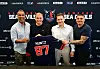 Patrick Esume, Stefan Kuntz, Mark Weitz und Miguel Boock halten ein Sea-Devils-Trikot und lachen in die Kamera