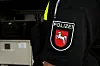 Uniformärmel eines Polizeibeamten mit dem Ärmelabzeichen der Polizei Niedersachsen. Das rote Wappen mit dem weißen Pferd ist klar erkennbar.