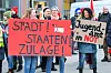 Mit Schildern und Transparenten demonstrierten Teilnehmer in Hamburg-während eines Warnstreiks. Auf den Schildern steht die Aufschrift „Stadtstaatenzulage jetzt“ und „Jugendamt in Not“. (Archivbild)