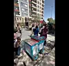 Mit einer Peitsche holt ein Taliban gegen Umstehende aus.