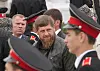 Ein Mann mit langem Bart steht bei einer Militärparade zwischen Soldaten