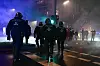Polizeibeamte gehen während der Silvesternacht in Neukölln über eine Straße.
