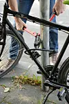 Ein Mann versucht mit einem Bolzenschneider ein Fahrradschloss aufzubrechen (gestellte Szene).